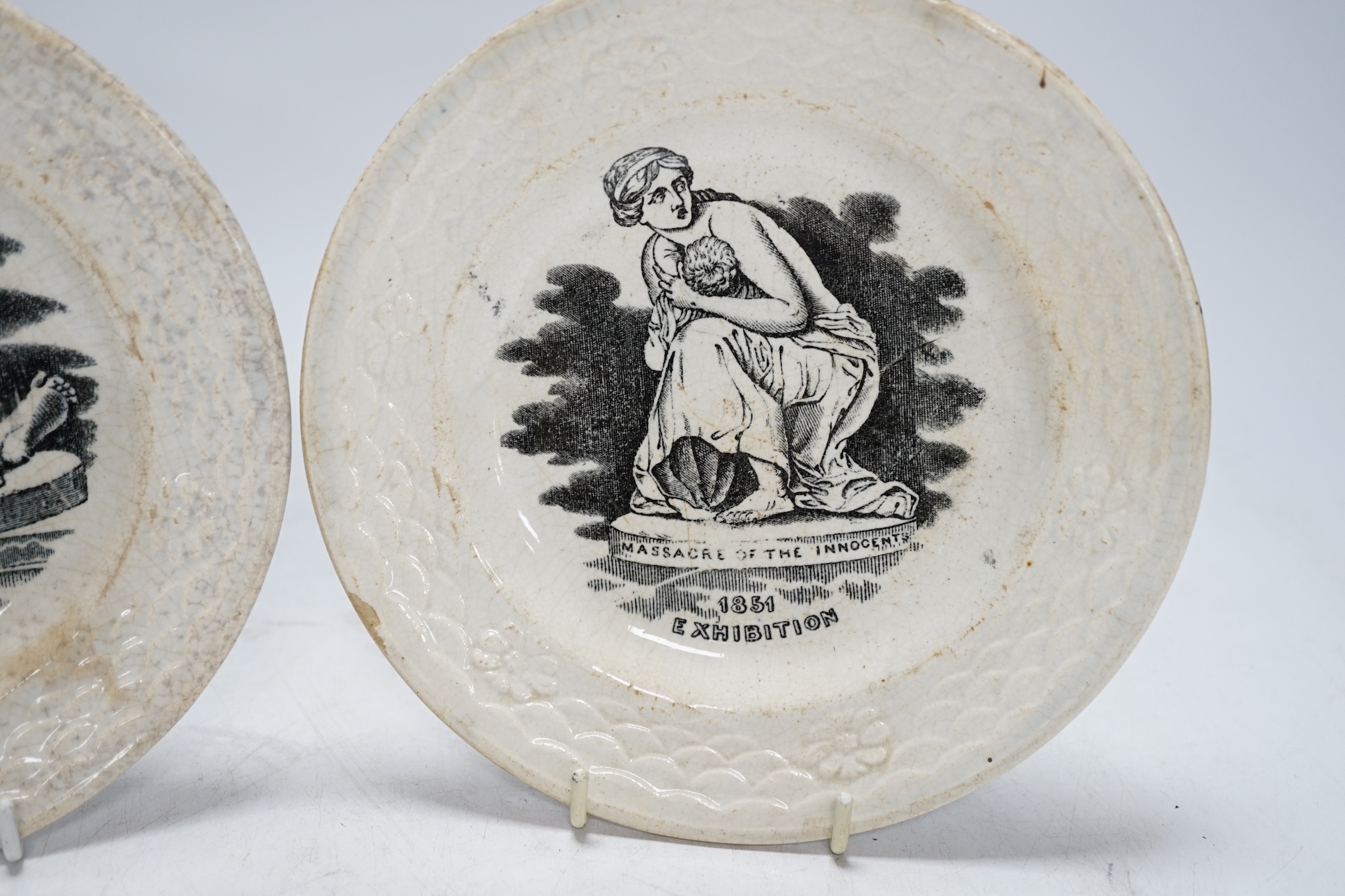 From the Studio of Fred Cuming. A pair of printed 1851 exhibition plates ‘Boy with Punchinello’ and ‘Massacre of the Innocent’, 17cm in diameter. Condition - poor to fair